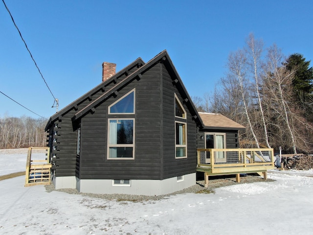 snow covered property featuring a deck