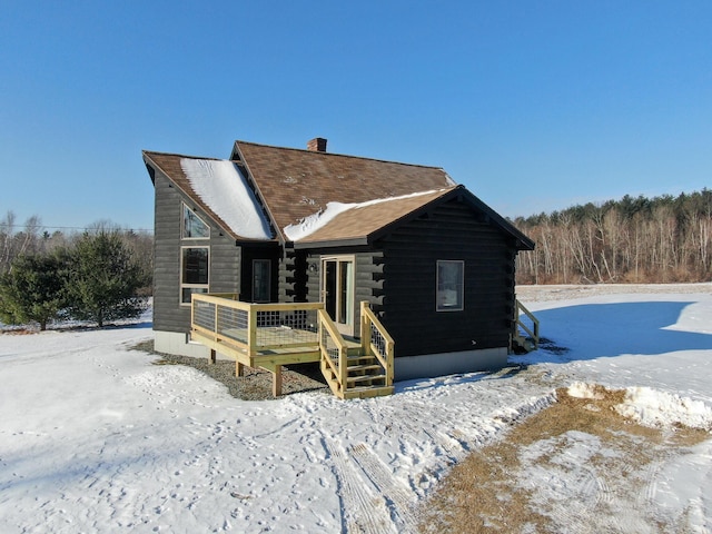 snow covered house with a wooden deck