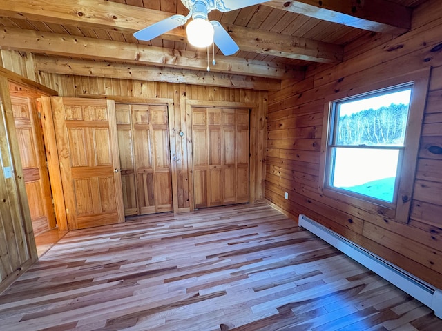 unfurnished bedroom with a baseboard heating unit, wooden walls, light wood-type flooring, wooden ceiling, and beam ceiling