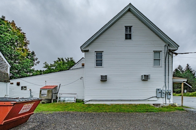 view of side of home with a wall mounted air conditioner