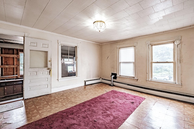 spare room with baseboard heating, ornamental molding, and light parquet floors