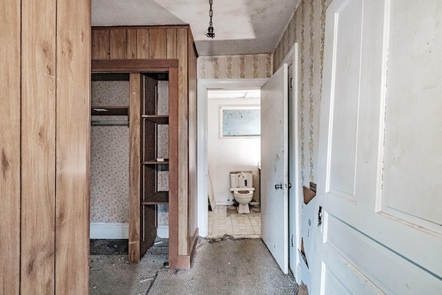 bathroom featuring toilet and wooden walls