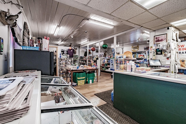 miscellaneous room featuring a drop ceiling, hardwood / wood-style floors, and a workshop area