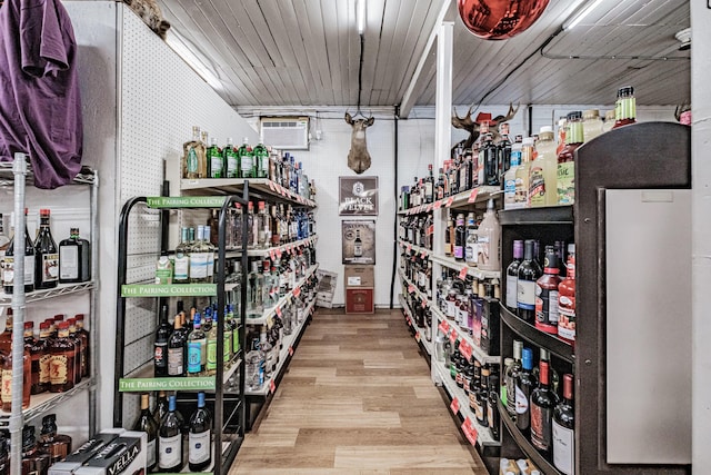 wine area with a wall mounted air conditioner and light hardwood / wood-style flooring