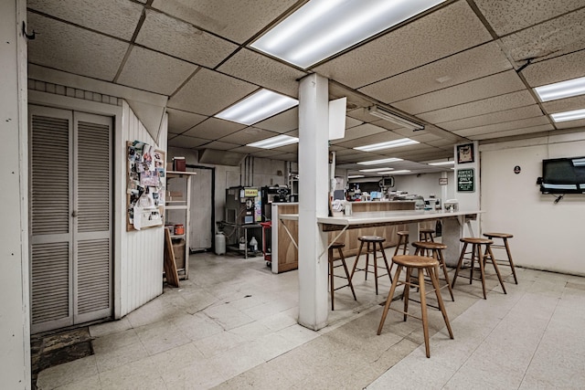 kitchen with a paneled ceiling, a breakfast bar, and kitchen peninsula