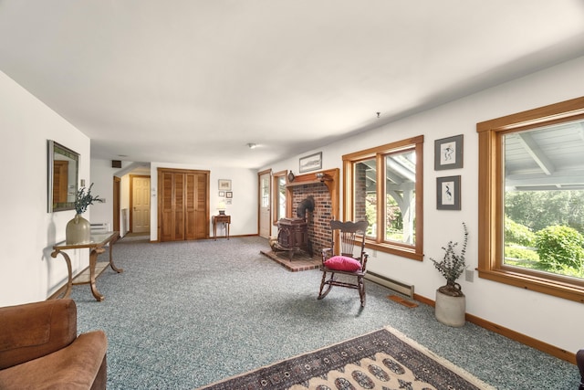 living area featuring plenty of natural light, carpet, and a wood stove