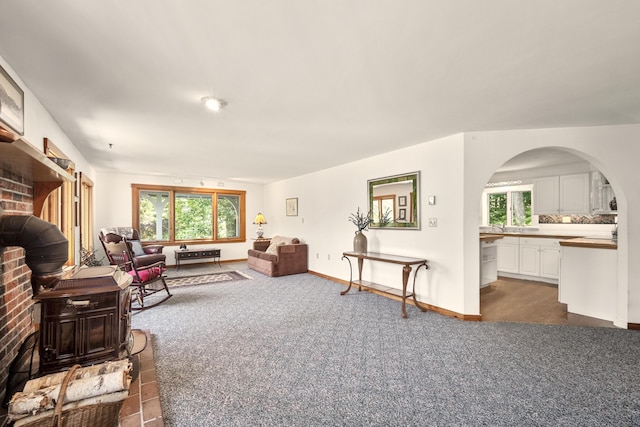 living room with dark carpet and a brick fireplace