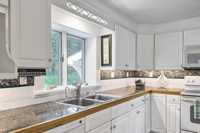 kitchen with white appliances, white cabinetry, backsplash, and sink