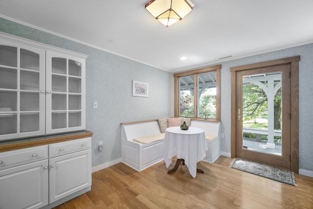 dining area with light hardwood / wood-style floors and crown molding