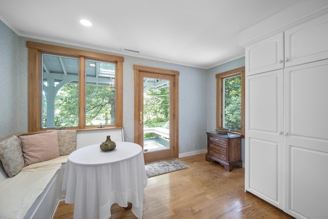 dining area with light hardwood / wood-style floors and crown molding