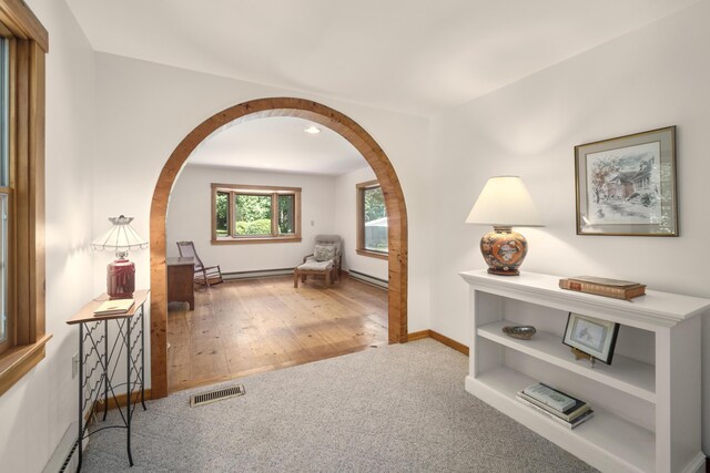 hall featuring carpet flooring and baseboard heating