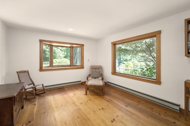 sitting room with a baseboard radiator and light hardwood / wood-style flooring