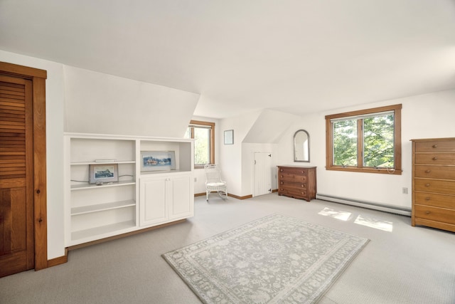 bedroom featuring a baseboard heating unit, multiple windows, and light colored carpet