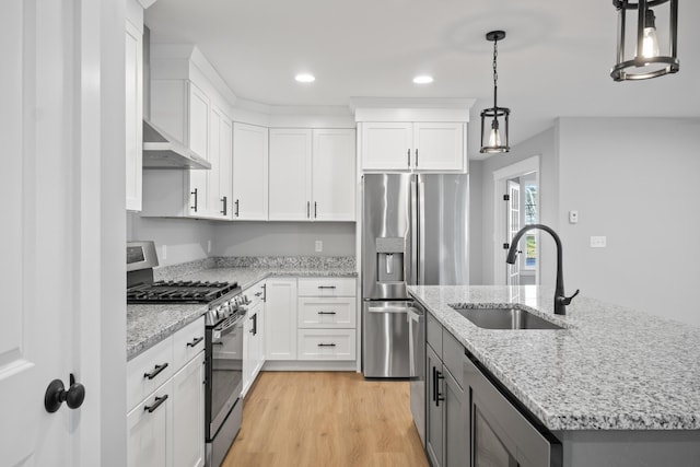 kitchen with white cabinets, appliances with stainless steel finishes, and pendant lighting