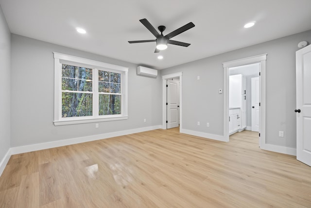 unfurnished bedroom with ceiling fan, light hardwood / wood-style floors, connected bathroom, and a wall unit AC