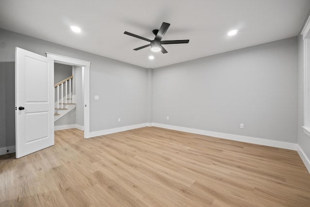 empty room with ceiling fan and light hardwood / wood-style flooring