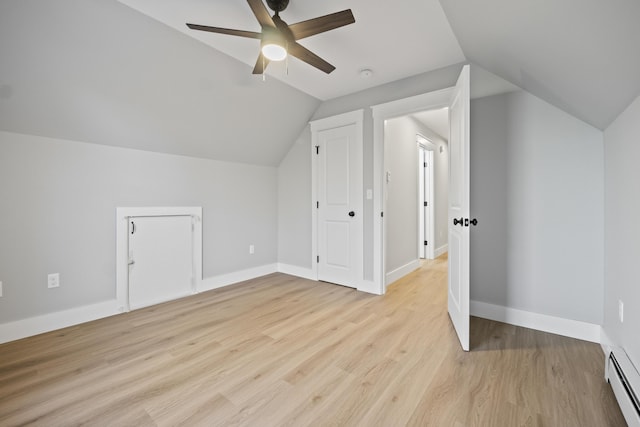 additional living space featuring ceiling fan, baseboard heating, light hardwood / wood-style flooring, and vaulted ceiling