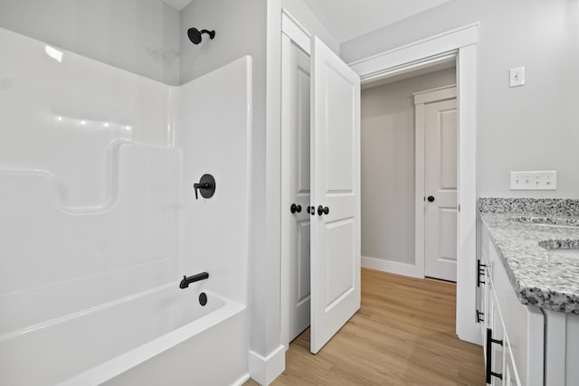 bathroom featuring shower / bathing tub combination, wood-type flooring, and vanity