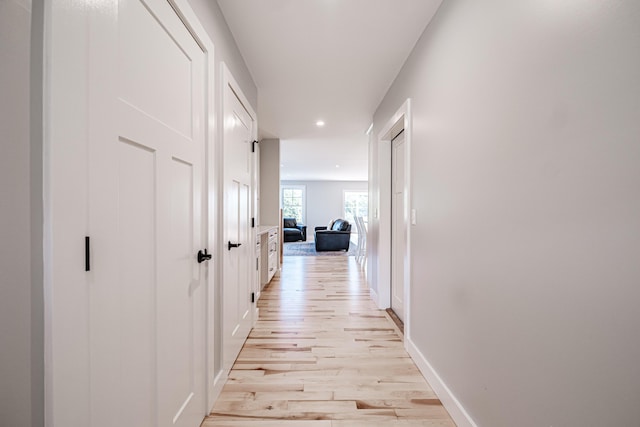 corridor with light hardwood / wood-style floors