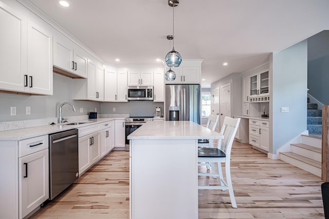 kitchen with appliances with stainless steel finishes, white cabinetry, and a center island