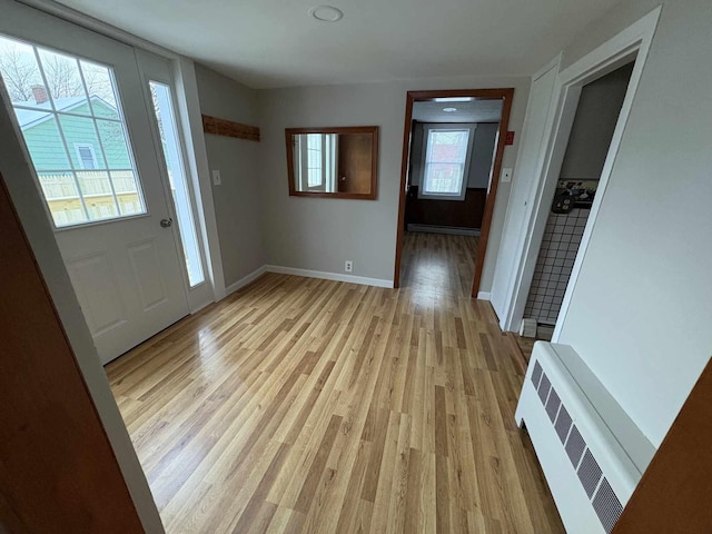 entryway with a baseboard radiator, light hardwood / wood-style flooring, and a wealth of natural light