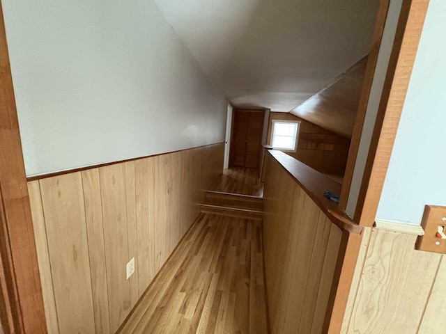 staircase with wood-type flooring and vaulted ceiling