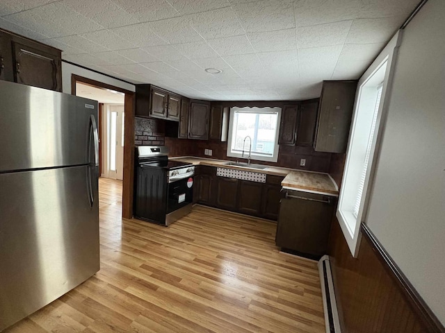 kitchen with backsplash, appliances with stainless steel finishes, dark brown cabinetry, sink, and a baseboard radiator