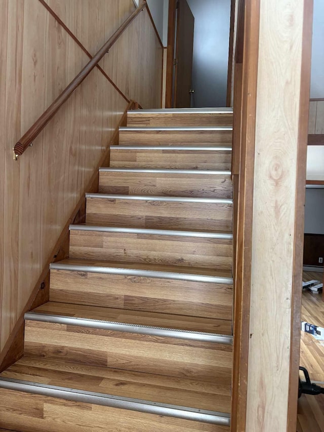 staircase featuring wood walls