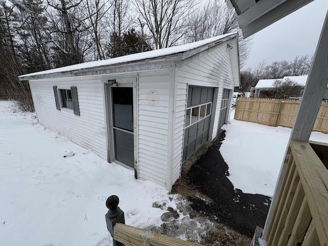 snow covered structure featuring a garage