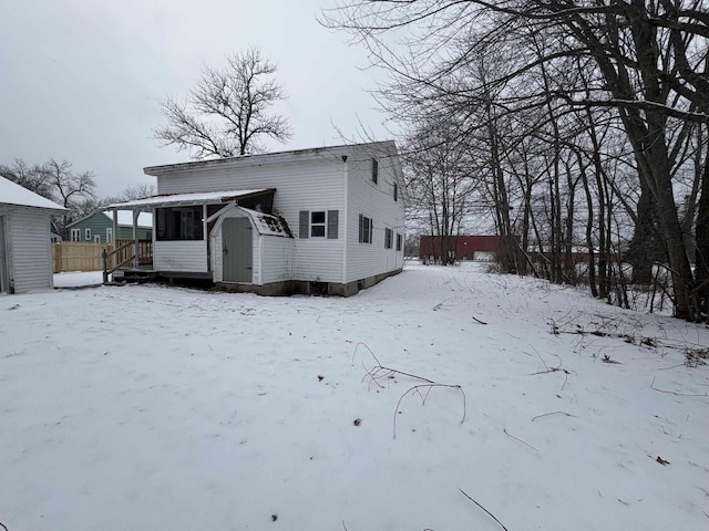 snow covered property with a storage shed