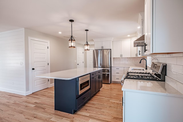 kitchen featuring stainless steel appliances, white cabinets, a center island, ventilation hood, and pendant lighting