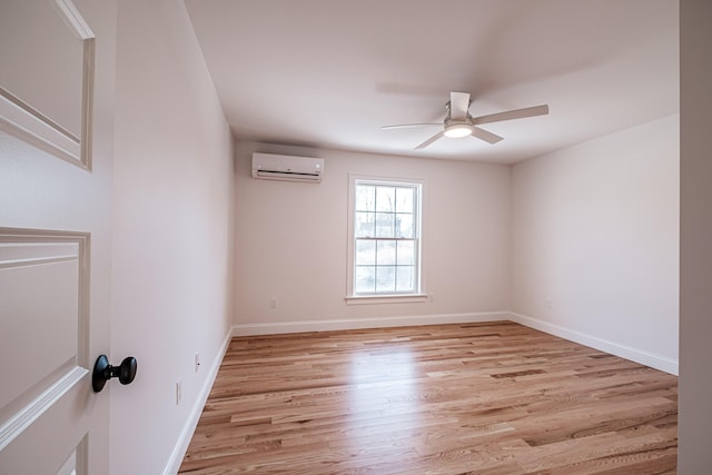 unfurnished room with ceiling fan, light wood-type flooring, and an AC wall unit