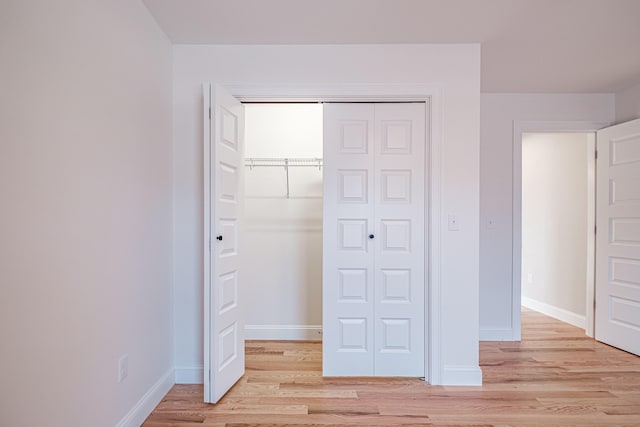 unfurnished bedroom with light hardwood / wood-style floors and a closet