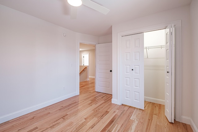 unfurnished bedroom with ceiling fan, light hardwood / wood-style floors, and a closet