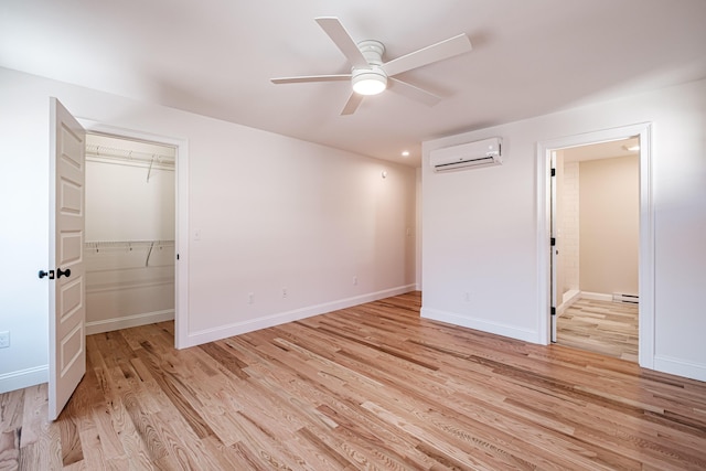 unfurnished bedroom featuring a closet, ceiling fan, light wood-type flooring, and a wall mounted AC