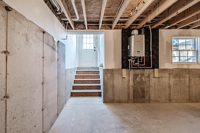 basement with water heater and a healthy amount of sunlight