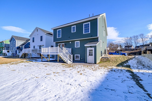 snow covered rear of property featuring a deck