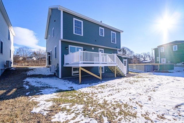 snow covered property featuring central AC and a wooden deck