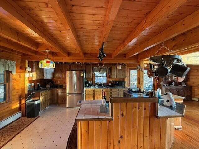 55 Brown Rd, Oakfield, ME 04763 - kitchen featuring wooden walls, stainless steel refrigerator, hanging light fixtures, kitchen peninsula, and beam ceiling