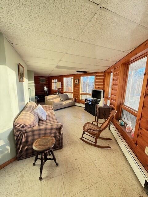 55 Brown Rd, Oakfield, ME 04763 - living room featuring a paneled ceiling, rustic walls, and baseboard heating