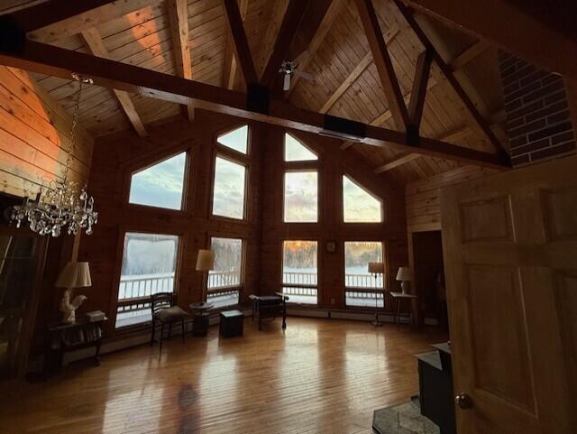 55 Brown Rd, Oakfield, ME 04763 - unfurnished living room featuring beamed ceiling, wood-type flooring, wooden ceiling, and wooden walls