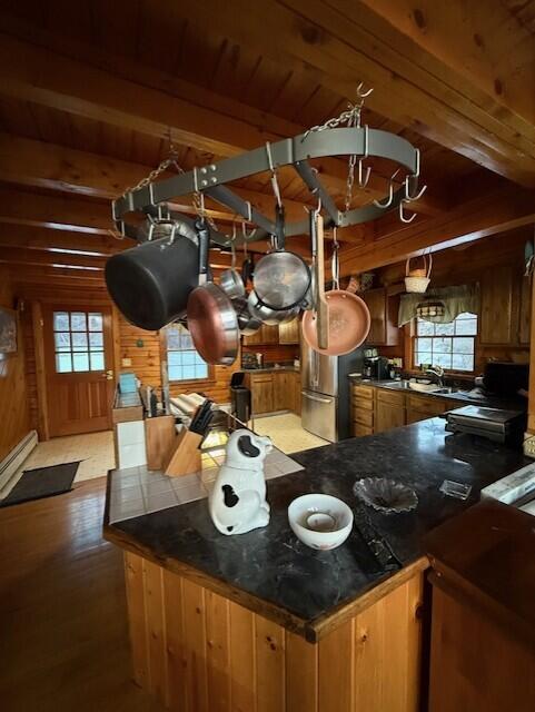 55 Brown Rd, Oakfield, ME 04763 - kitchen featuring wooden walls, wooden ceiling, kitchen peninsula, beamed ceiling, and light wood-type flooring