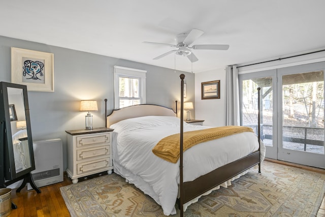 bedroom featuring access to outside, heating unit, ceiling fan, and dark hardwood / wood-style floors