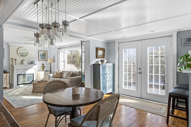 dining area featuring french doors, a fireplace, crown molding, and dark hardwood / wood-style floors