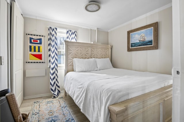 bedroom with crown molding and wood-type flooring