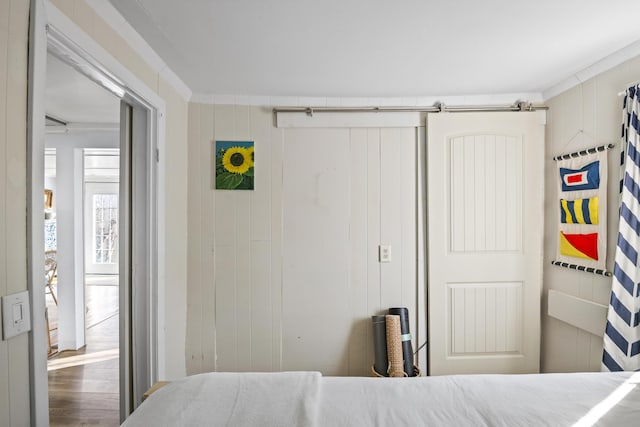 bedroom featuring wood walls and ornamental molding