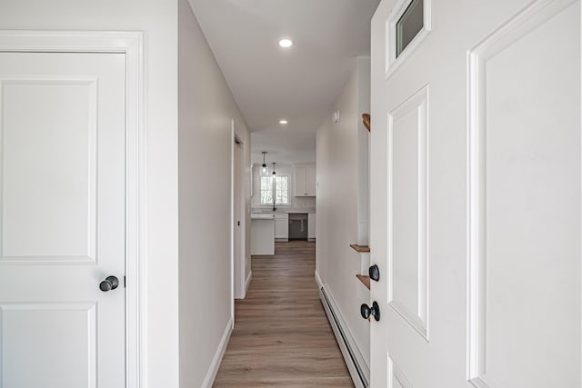 hallway featuring light hardwood / wood-style floors and a baseboard radiator