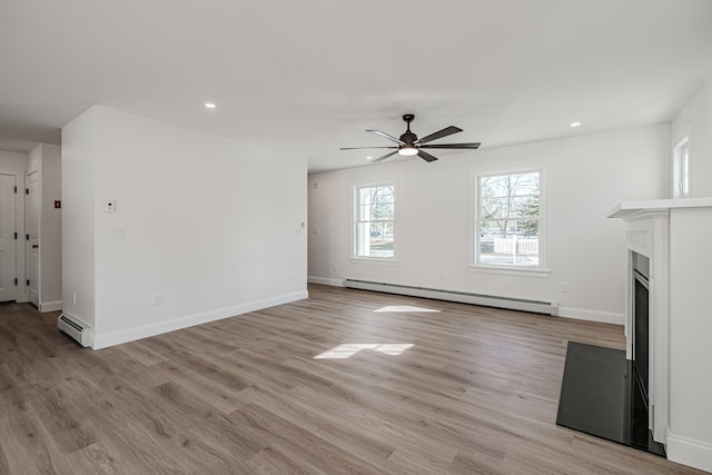 unfurnished living room featuring ceiling fan, light hardwood / wood-style flooring, and a baseboard radiator