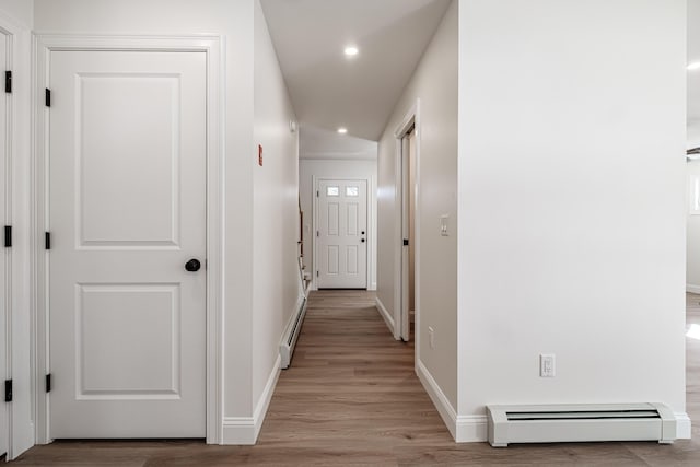 corridor featuring baseboard heating and light hardwood / wood-style flooring