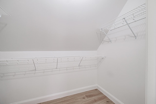 spacious closet featuring lofted ceiling and hardwood / wood-style flooring